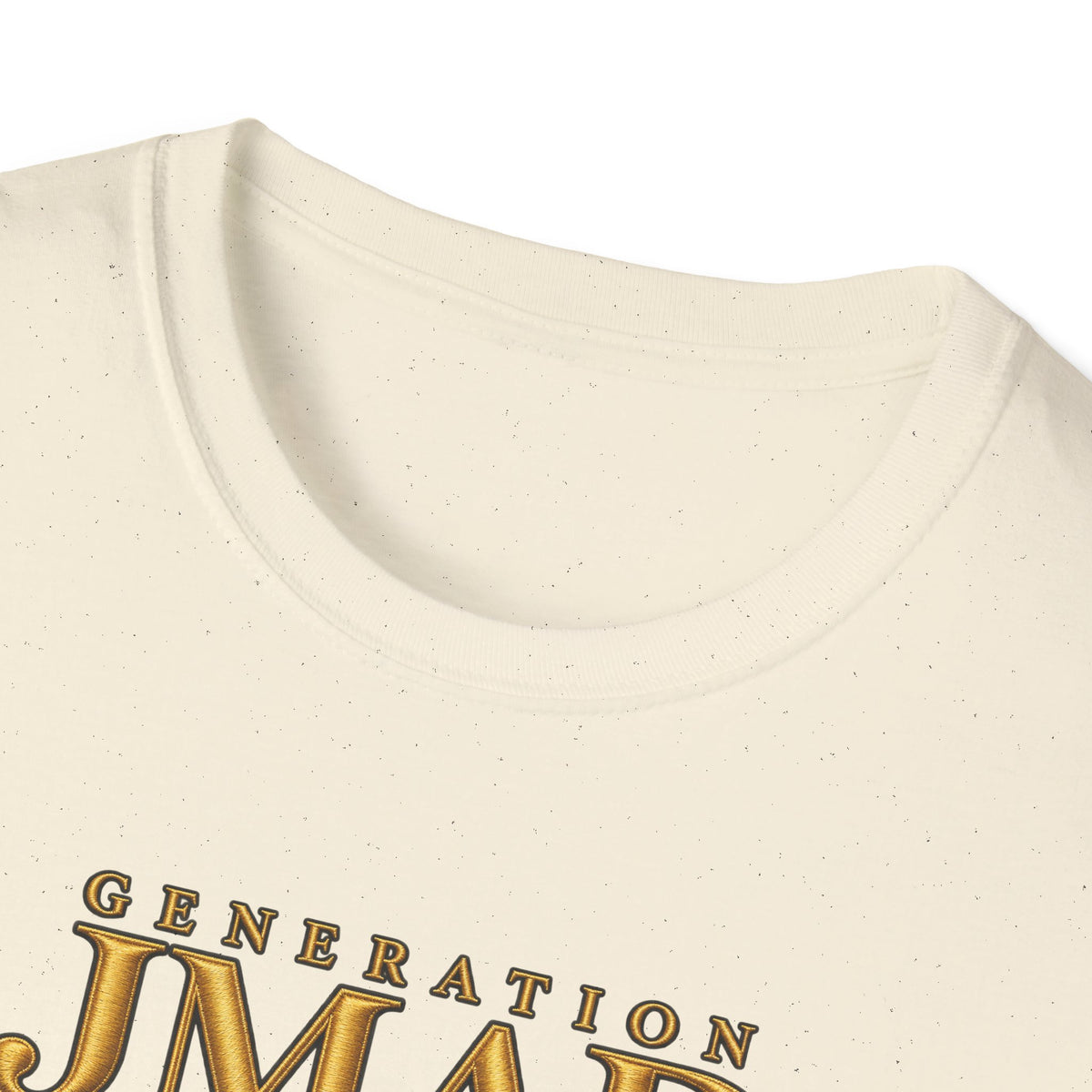 Close-up of a cream-colored t-shirt with a textured speckled finish, featuring a gold metallic-style graphic that reads 'GENERATION JMAE' on the front.