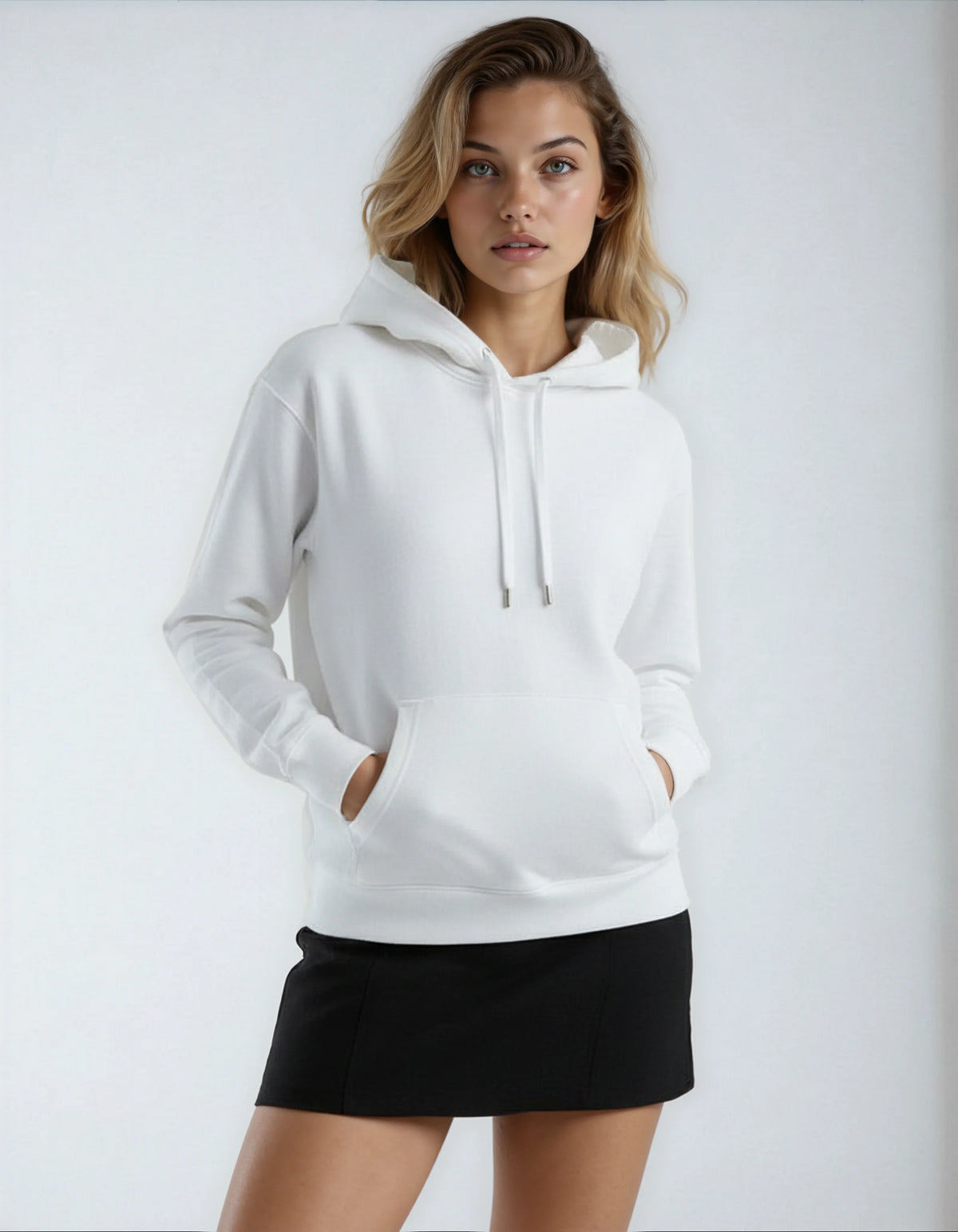 Woman wearing a white hoodie and black skirt on a plain background